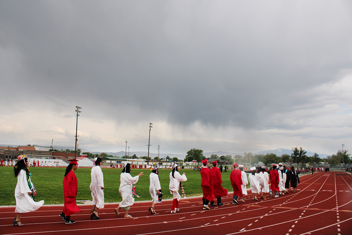 High school graduates walking the football field